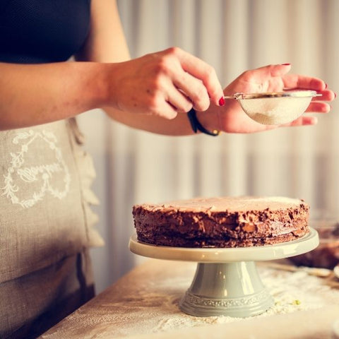 Women decorating a home-made chocolate cake 