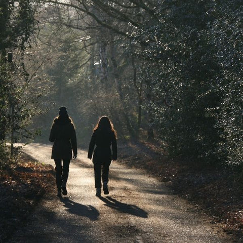 A mother and daughter walking through the woods together