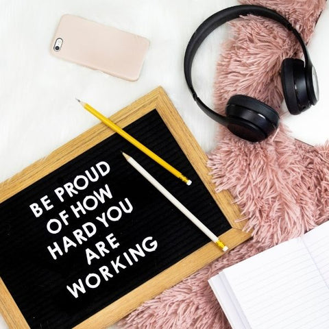 A board of calligraphy showing "be proud of how hard you are working"