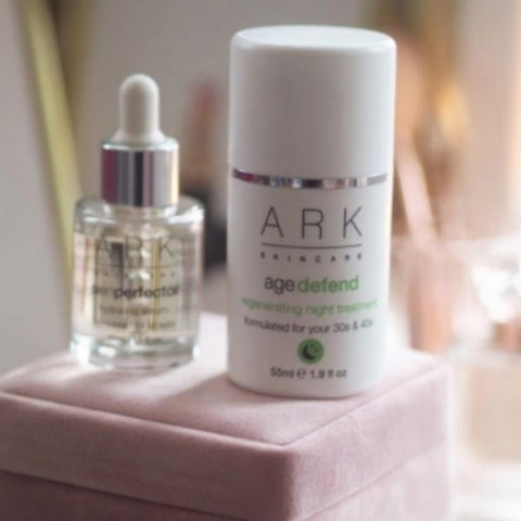 Product Image of ARK Skincare's Defend Night Treatment on top of a velvet pink jewellery box next to a bottle of ARK's Radiance Serum.
