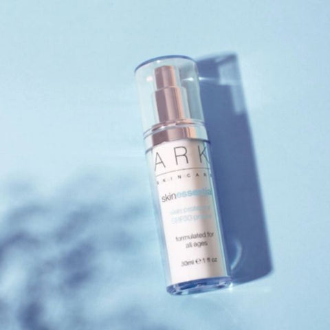 Product Image of ARK Skincare's Skin Protector SPF 30 Primer on a blue, sunlit background 