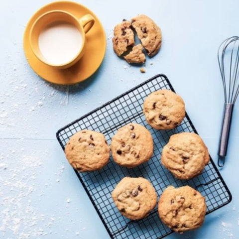 Image: Chocolate chip cookies on a cooling rack next to a mug of milk 