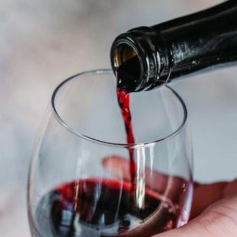 Image: Woman pouring a glass of red wine 