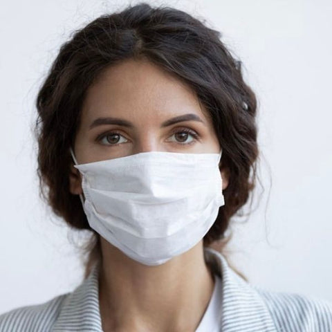 Image: Woman wearing a white disposable mask to cover her nose and mouth