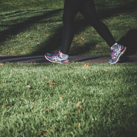 Person walking through a park wearing colourful trainers