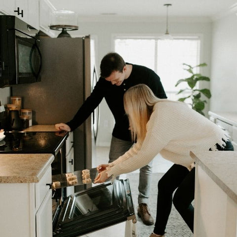 A couple cooking a Valentines day meal together in their kitchen at home