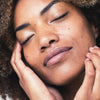 A close up shot of a women looking relaxed and at peace with her skin