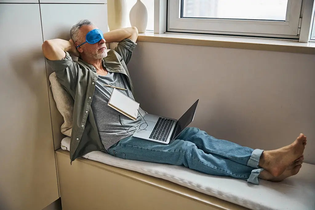 man taking a break from work with sleep mask on