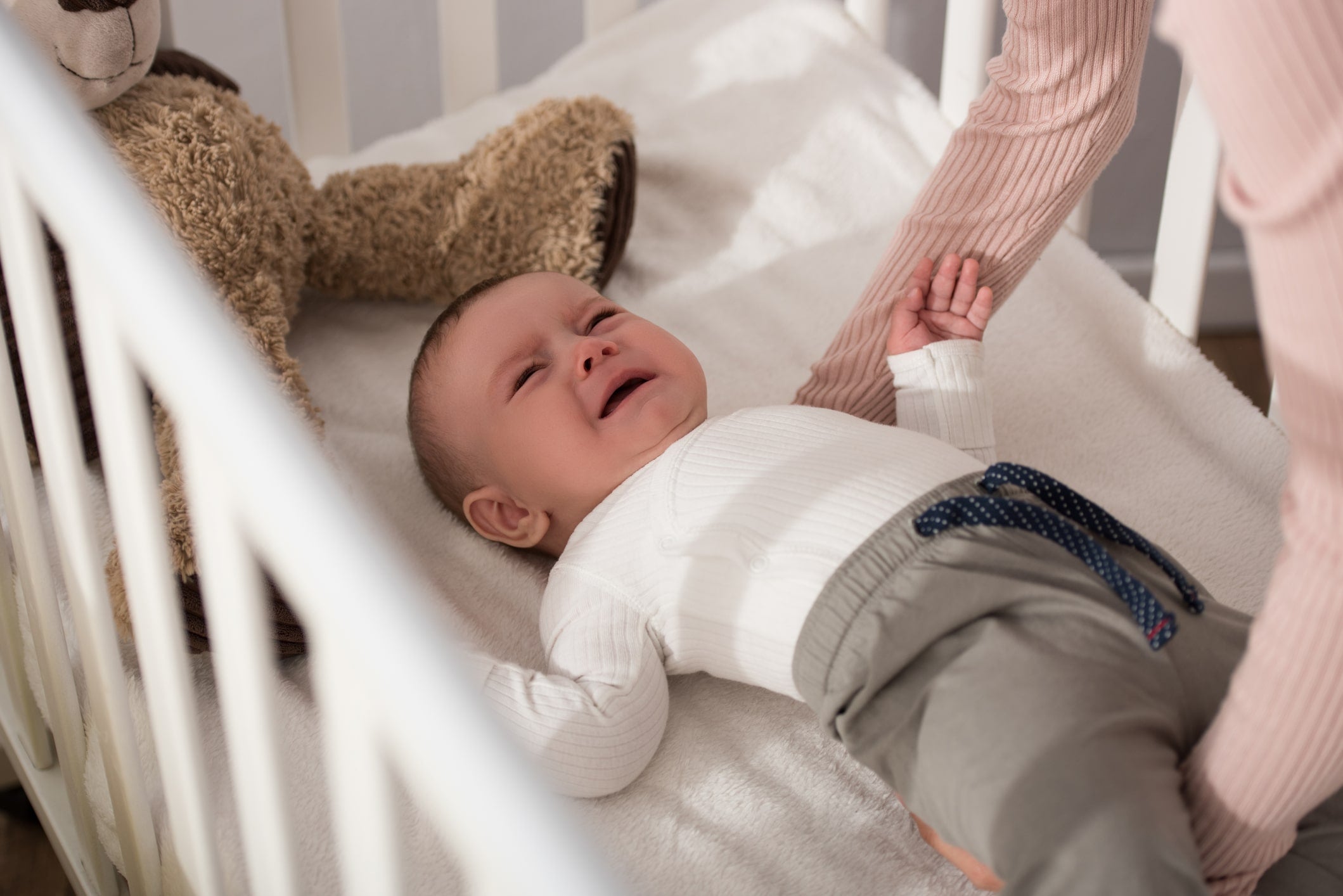 Mother learning how to help baby connect sleep cycles at night