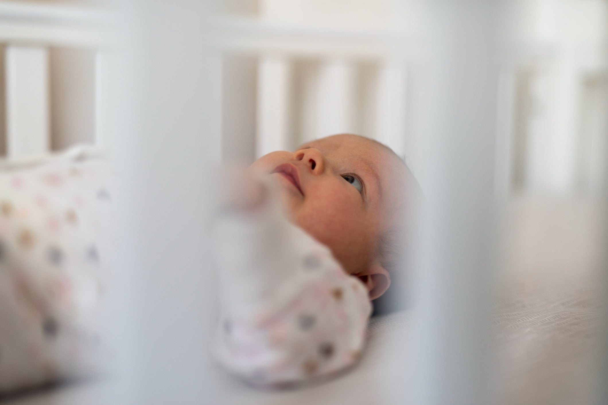 Baby lying awake because they can’t sleep in crib yet