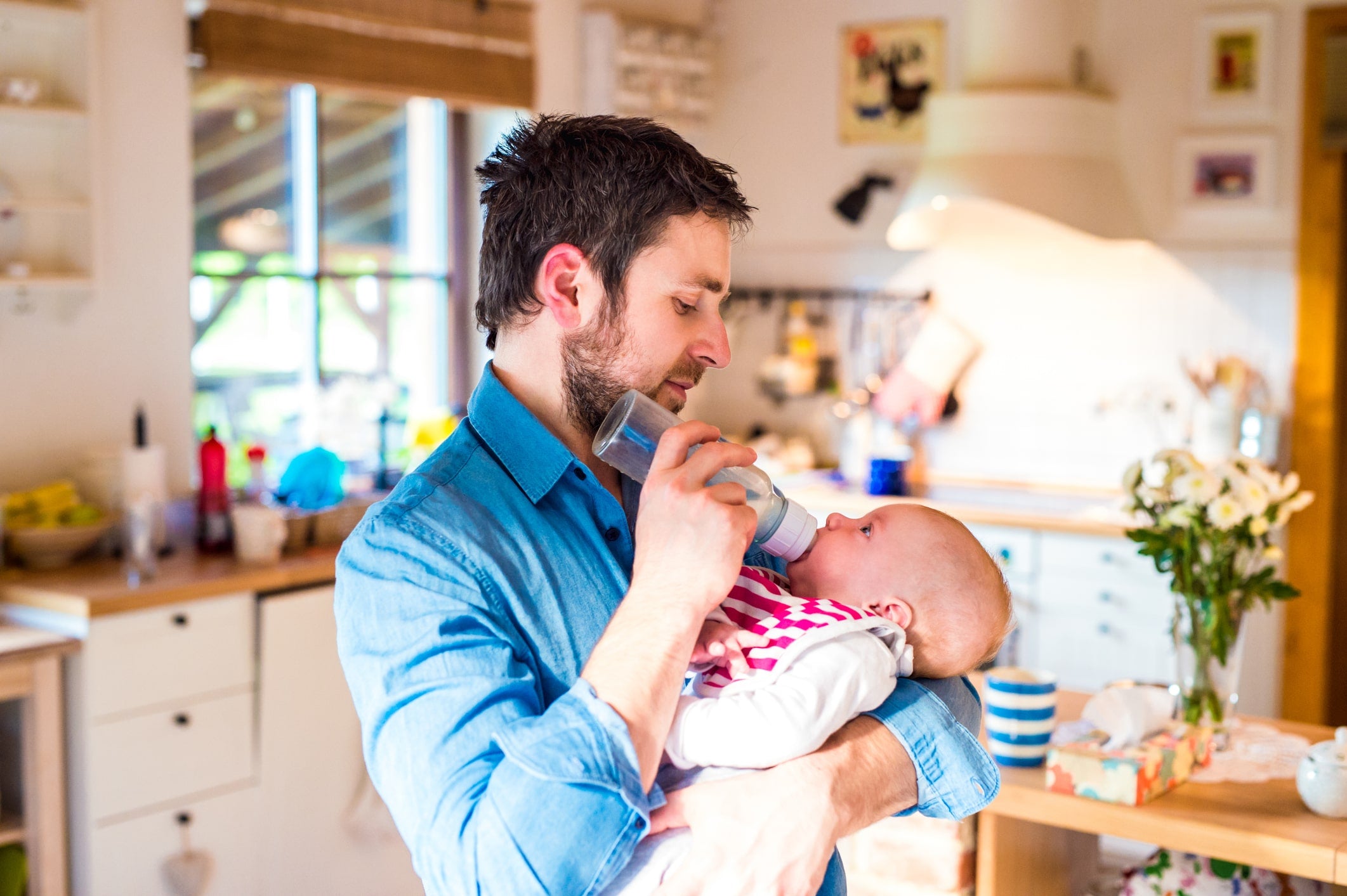 Dad feeding baby in best sleeping position for gassy baby