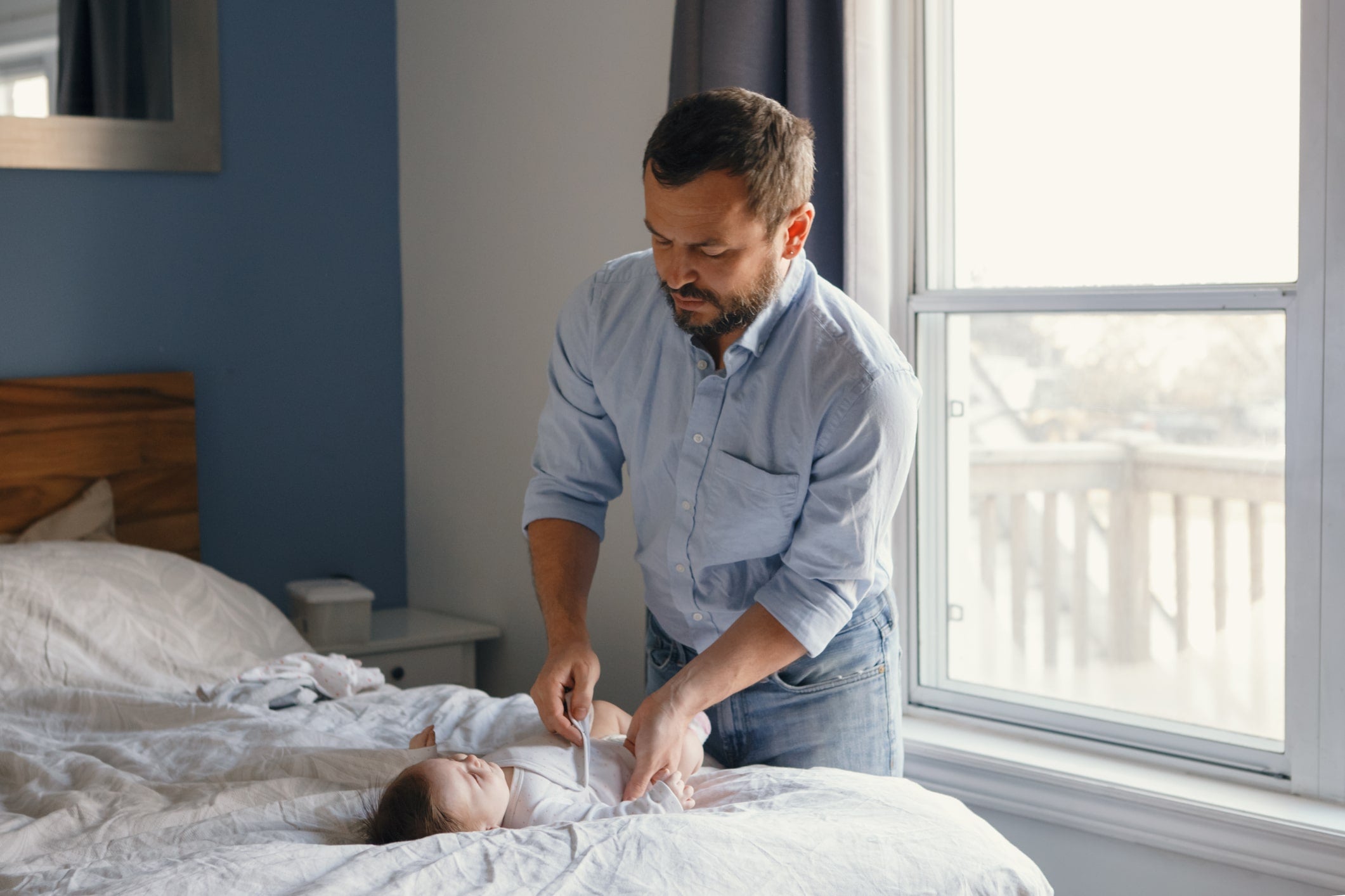 Dad learning how to dress baby for sleep in air conditioning