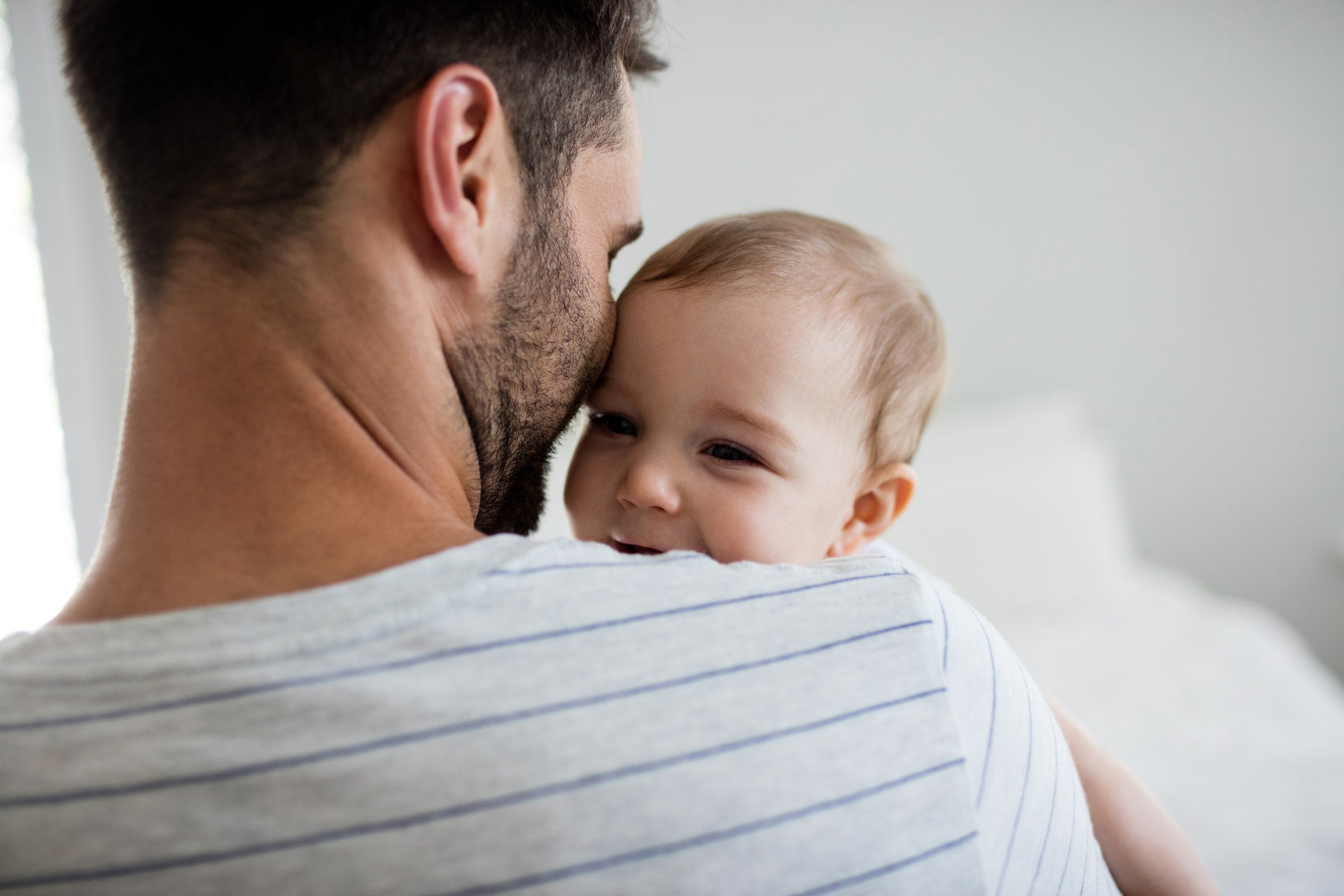 Father helping sleep training baby get to sleep at night