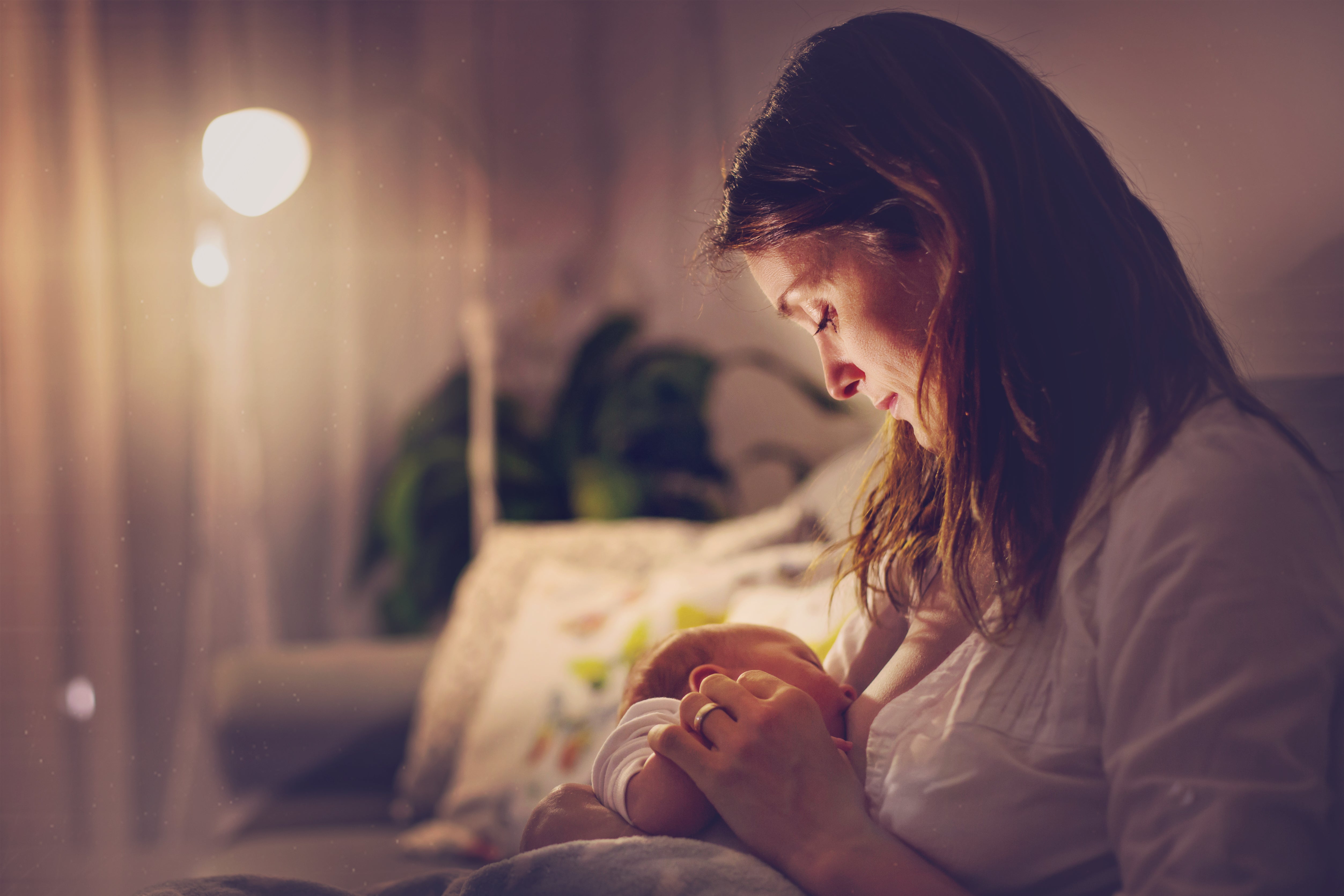 Mother feeding child after discovering baby crying at night