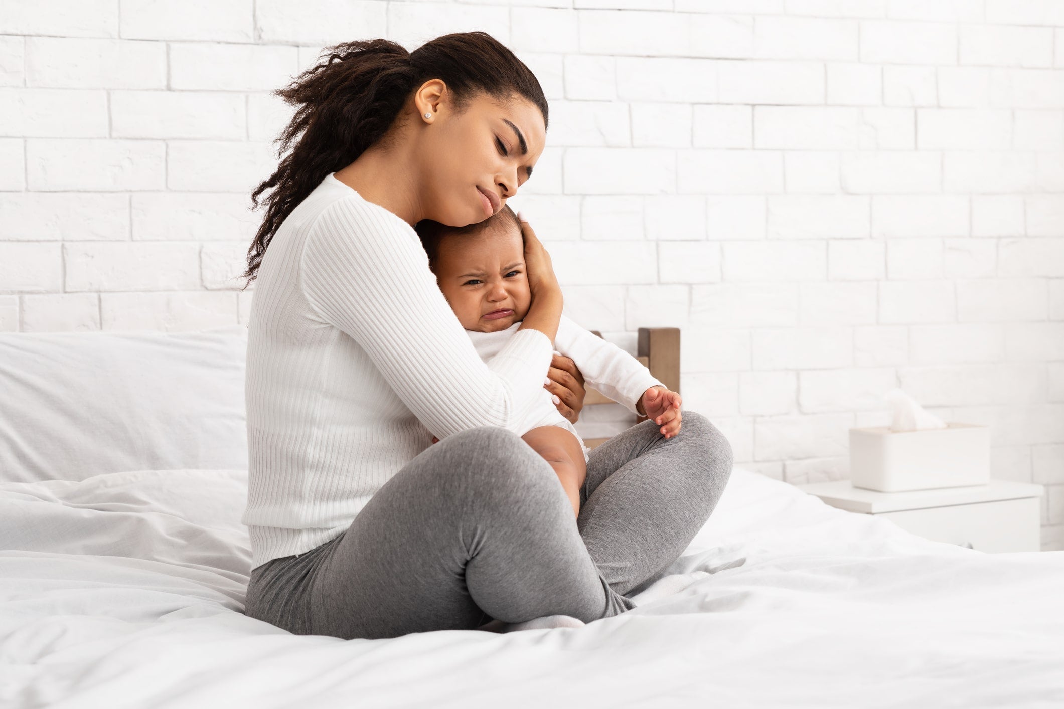 Mother comforting child suffering from hay fever in babies