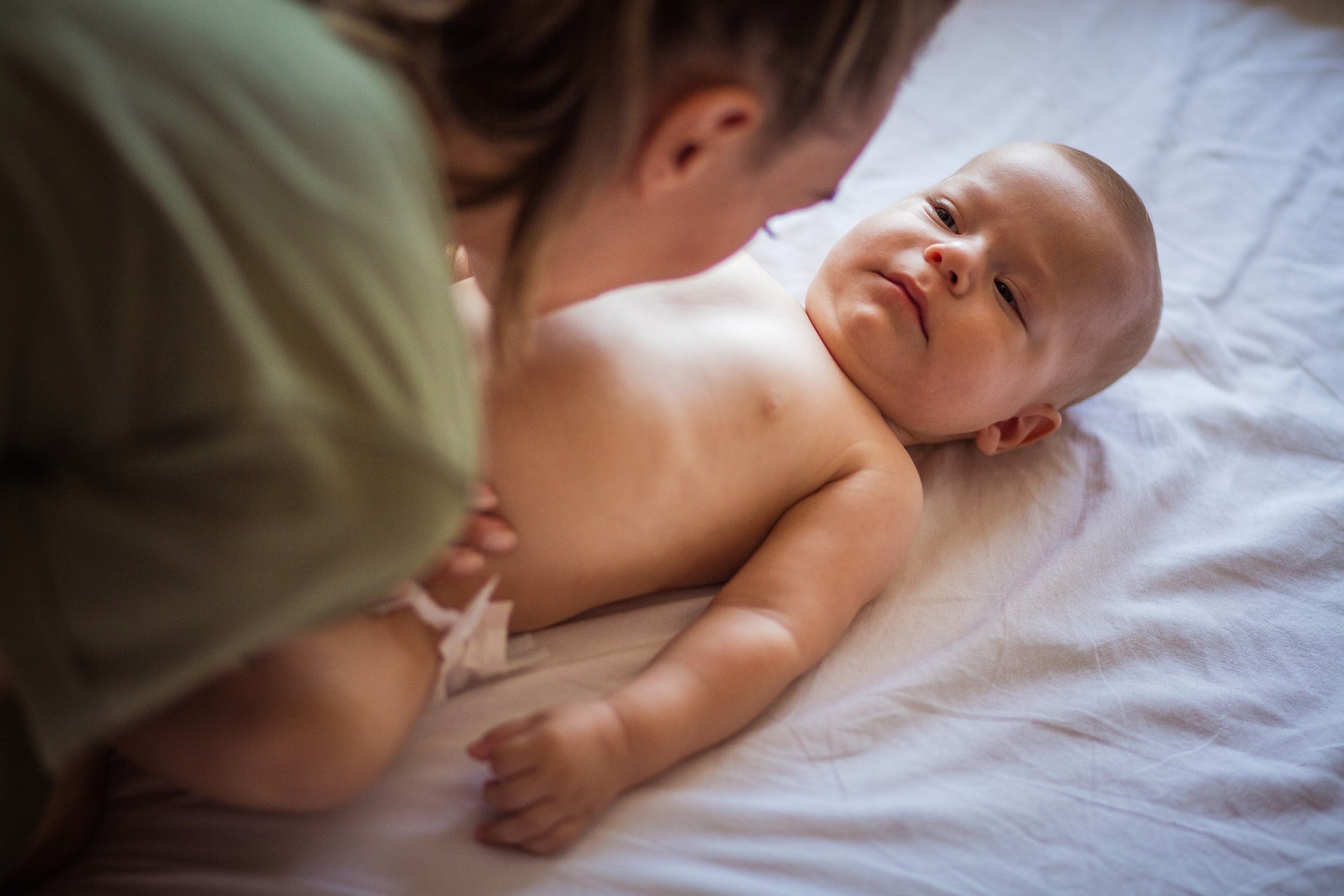 Mother kissing goodnight to sleep training baby