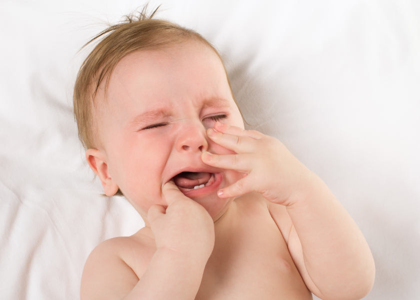 Example of unhappy baby crying at night while teething with first tooth 