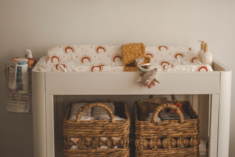 A side image of a change table stacked with nappy changing accessories.