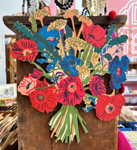 our wood flower bouquet wall hanging. it has red blue and yellow flowers