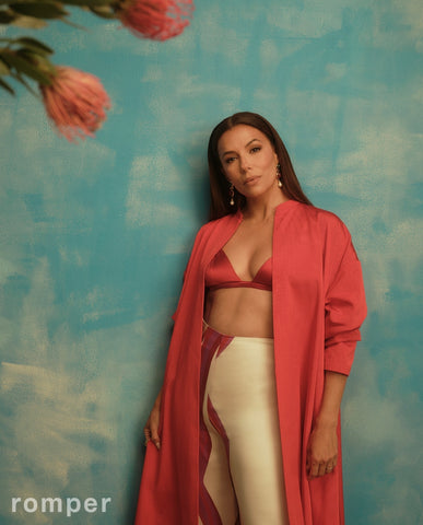 Eva Longoria in red bra top and duster posing against painted blue background for Romper Magazine June 2023 issue