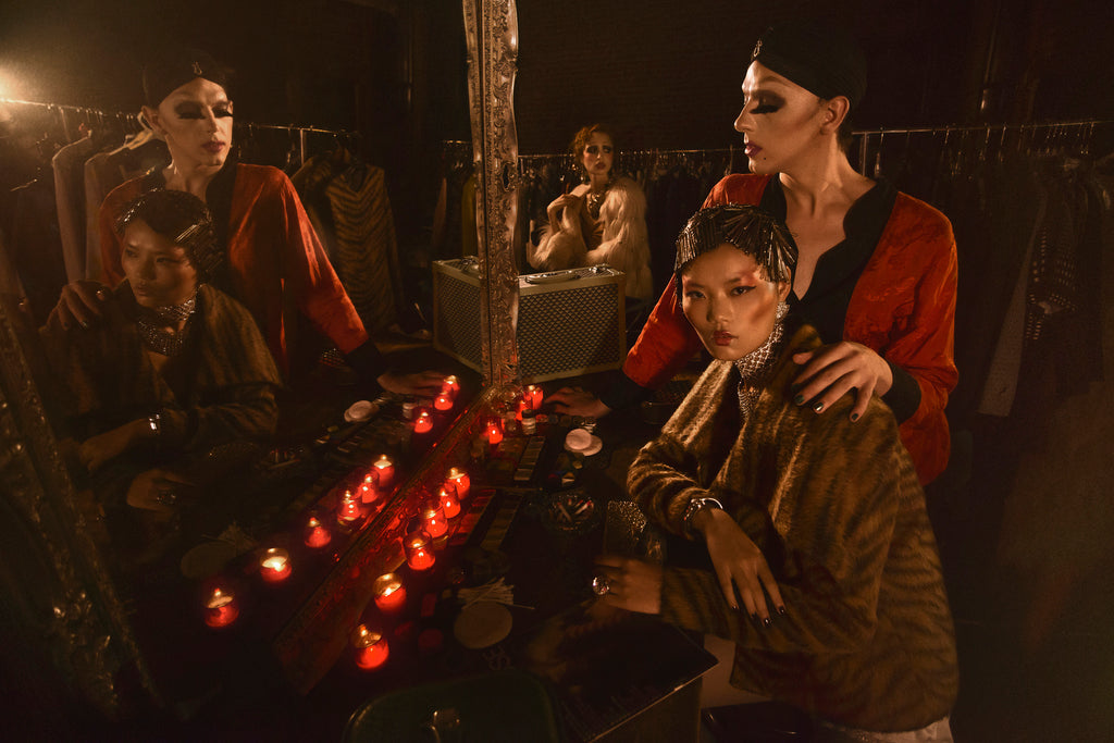 2 models pose for FAQ Magazine, surrounded by candles