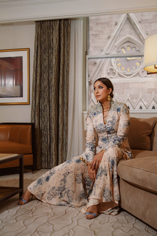 Amna Nawaz wearing ben-Amun earrings and necklace, posing on couch for L'Officiel India
