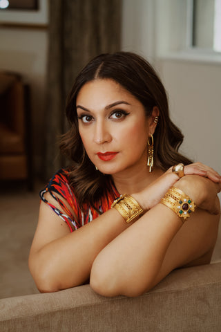 Close-up of Amna Nawaz, wearing Ben-Amun Tudores Collection bangles and 8th & 38th Collection earrings