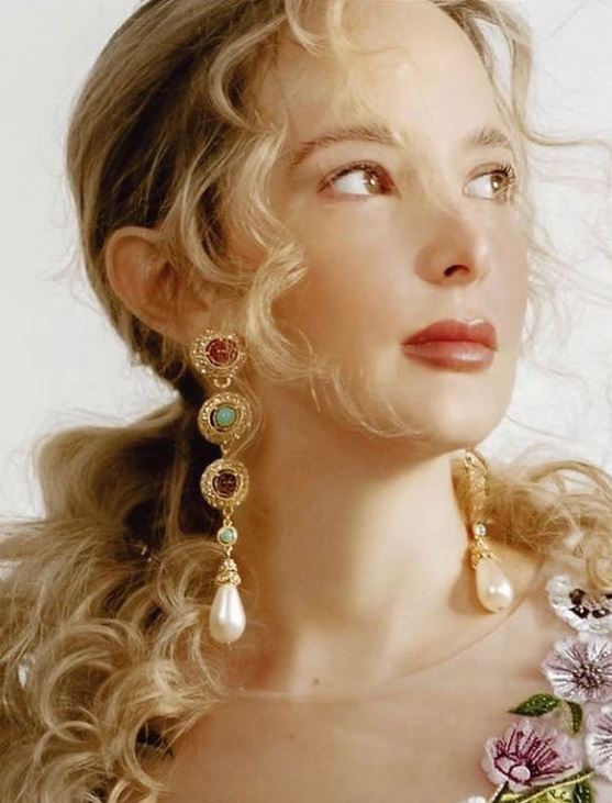 Blonde model in long gold-plated earrings