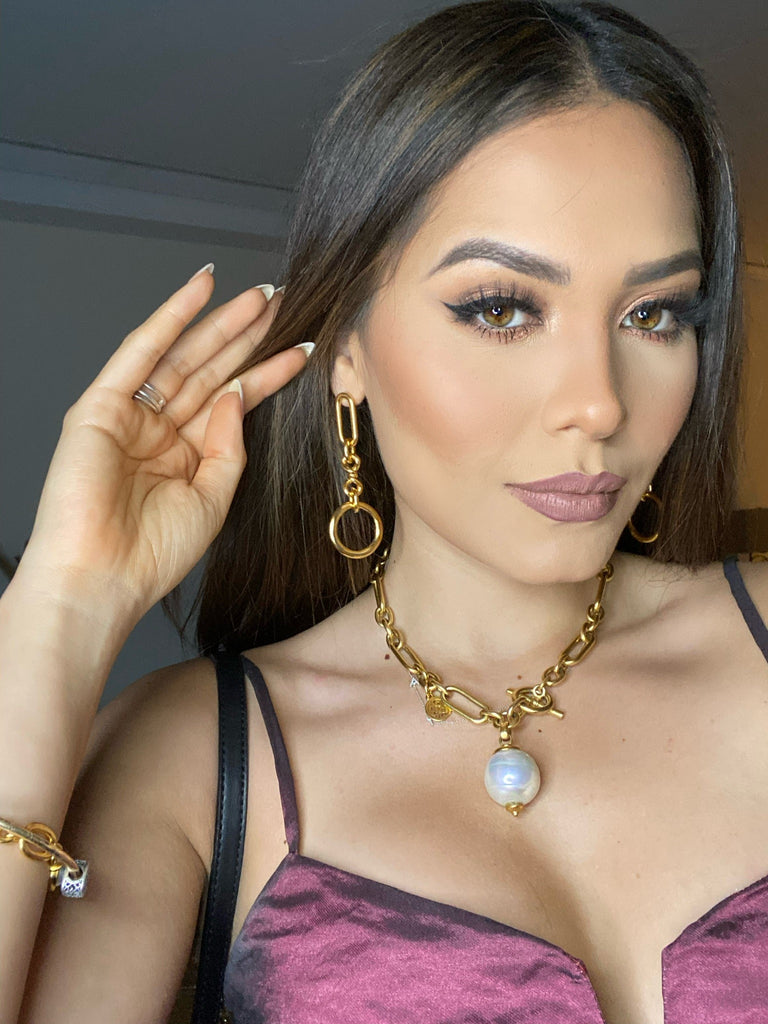 close up image of miss universe in gold chain earrings, necklace and bracelets
