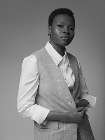 black and white photo of Shaunette Wilson in vest and white button up shirt, with silver clip-on  earrings