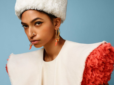 Woman in Ben-Amun gold coin earrings and white fur hat