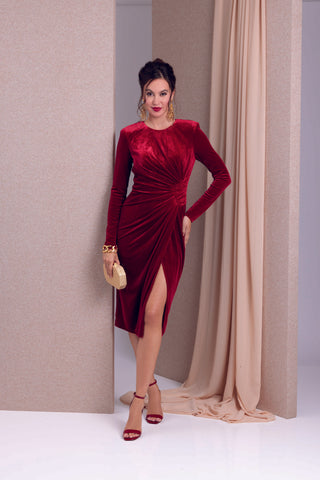 Model poses in dark red dress and gold Ben-Amun jewelry