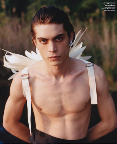 Male model poses shirtless with white wings and one crystal Ben-Amun earring