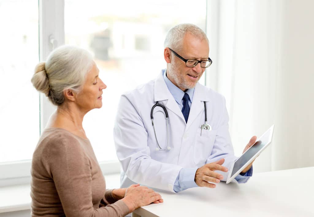 medicine, age, health care and people concept - smiling senior woman and doctor with tablet pc compu