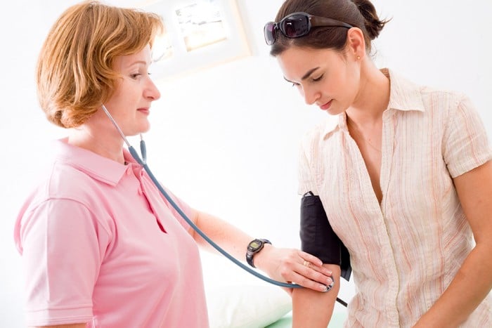 Nurse measuring the patient's blood-pressure.