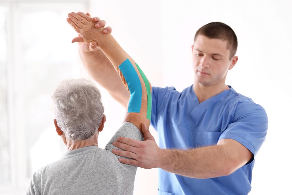 Physiotherapist working with elderly patient in clinic