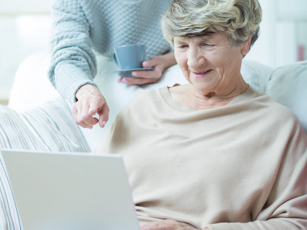 Elder woman with laptop surfing on the internet