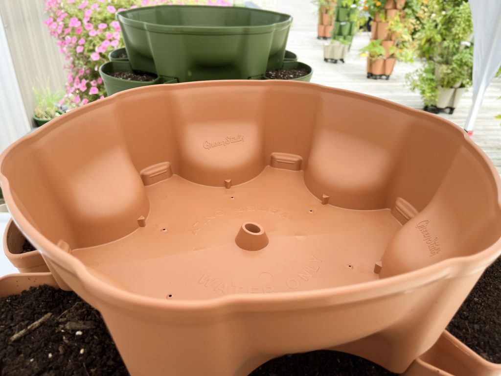 Photo of GreenStalk Vertical Planter top water reservoir with slanted funnel opening.