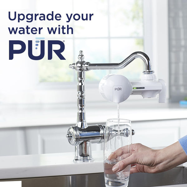 Image: A person filling a glass with crystal-clear water from a PUR PLUS Water Filtration System (PFM150W) faucet mount filter