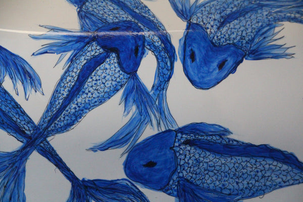 Detailed view of the painting of blue fish on a toilet