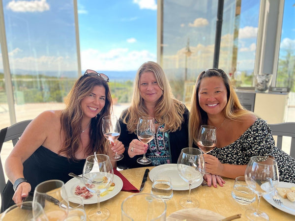 three beautiful women drinking wine in tuscany