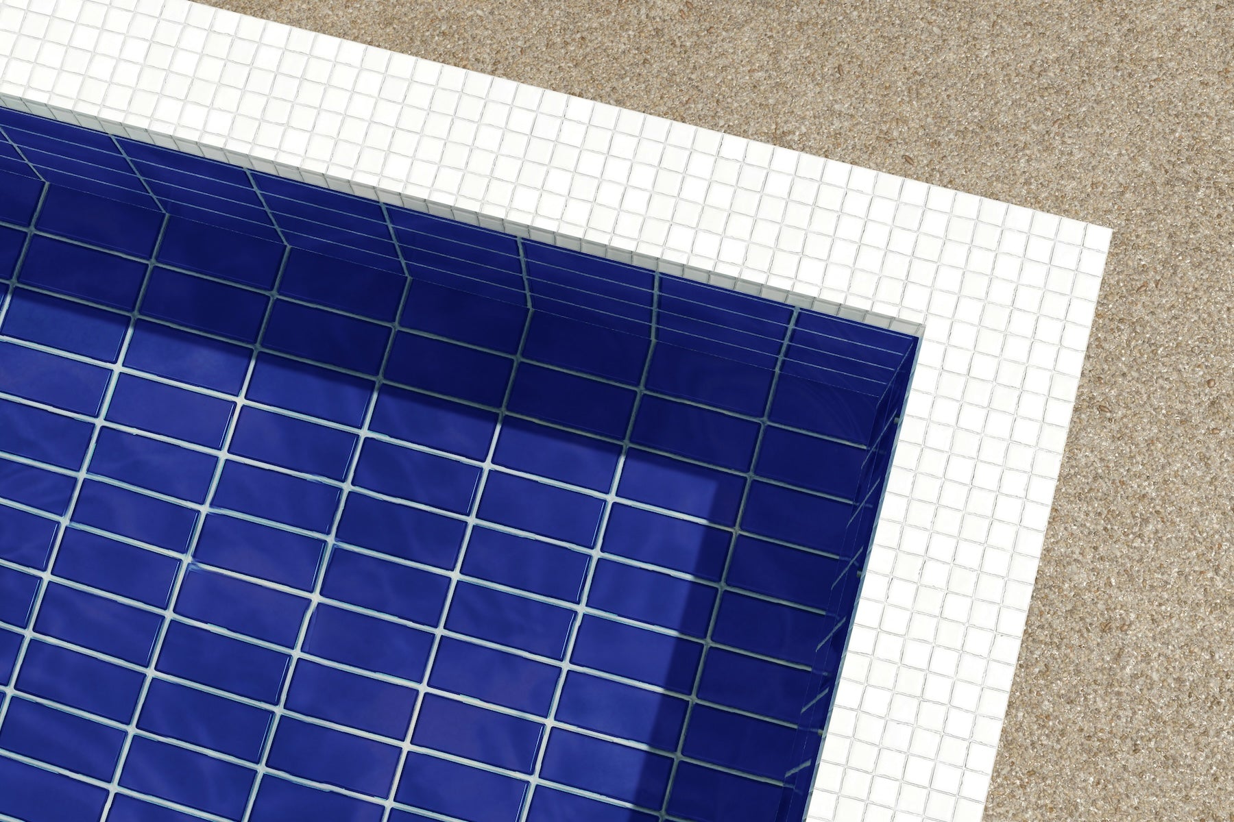 closeup shot of the corner of a modern blue tiled pool with a white mosaic tile border