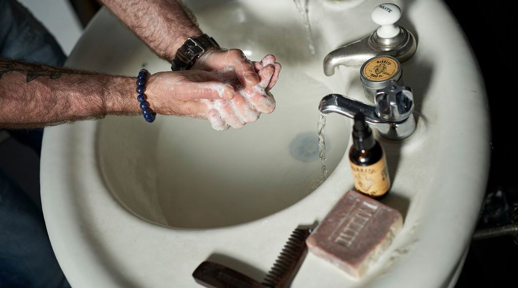 A man washing his hands at a vintage sink using Mammoth Beard Co beard and body wash soap