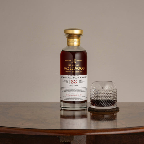 A bottle of The Tops whisky with a pour in a crystal glass