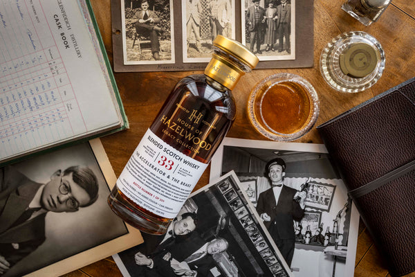 A bottle of The Accelerator and The Brake Blended Scotch Whisky lies atop family photos