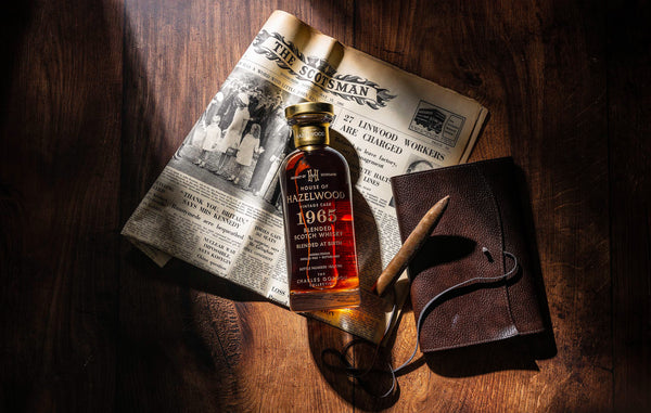 A bottle of Blended at Birth whisky laid on a historical newspaper