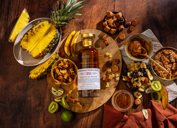 A bottle of Sunshine on Speyside surrounded by tropical fruits