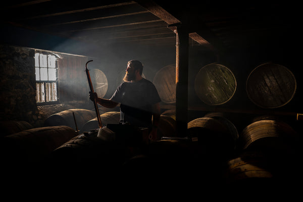 A warehouseman inspects a cask and sample