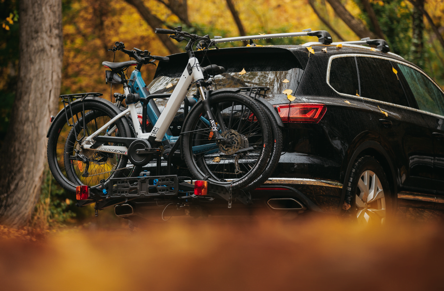 Two electric step-through bikes sit snug on an Ezigrip E-Rack 2 that's mounted on the back of an SUV