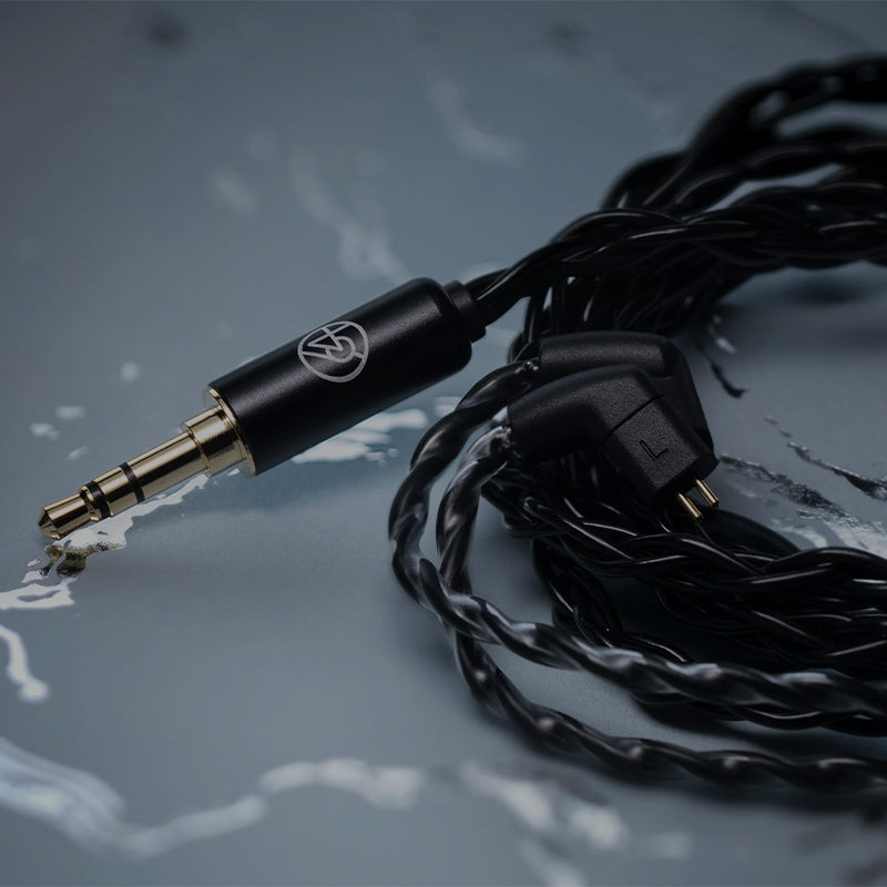 64audio premium cable coiled on polished surface 3.5mm and 2-pin connectors showing